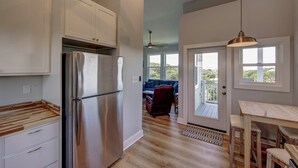 Une cuisine moderne dotée d’appareils électroménagers en acier inoxydable, de meubles blancs et d’un plan de travail en bois.