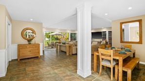A spacious living area with a dining table, comfortable seating, and a view of the outdoors.