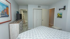 Een slaapkamer met een bed, een kaptafel en een deur naar de badkamer.