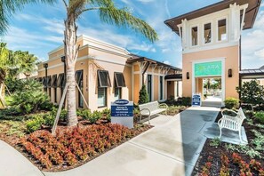 A hotel entrance with a sign for Solara Resort, a paved walkway, and a bench. - Elegant Family Home w/ Pool, Game Room, Themed Bedrooms (Kissimmee)