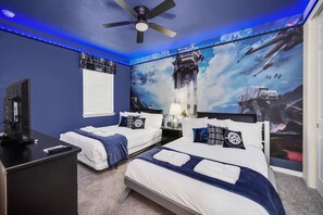 A bedroom with two beds, a ceiling fan, a TV, and Star Wars-themed wall art. - Elegant Family Home w/ Pool, Game Room, Themed Bedrooms (Kissimmee)