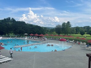 A swimming pool with multiple lanes, lounge chairs, and umbrellas.