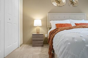 A bedroom with a bed, nightstand, lamp, and decorative wall pieces. - 1034 Lake Davenport Pool House for 6 near Disney (Davenport)