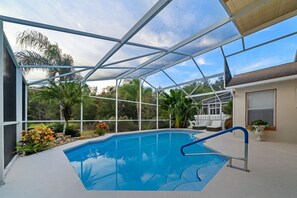 A swimming pool with a glass enclosure, surrounded by plants and a white fence. - 1034 Lake Davenport Pool House for 6 near Disney (Davenport)