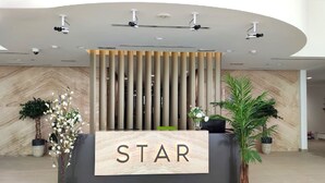 Un comptoir d’accueil avec une enseigne « STAR », un design moderne et des caméras de surveillance.