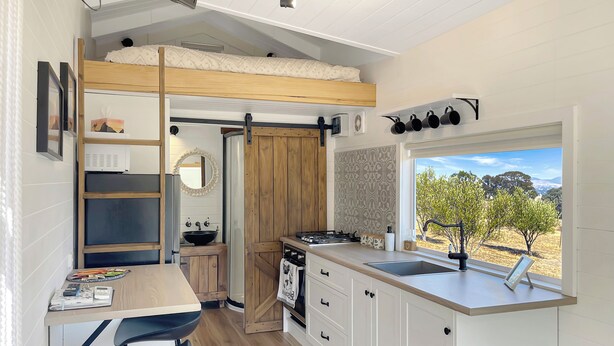 A compact kitchen with a wooden countertop, a sink, and a window with a view of trees. - Gem View - Tiny home (Barwite)