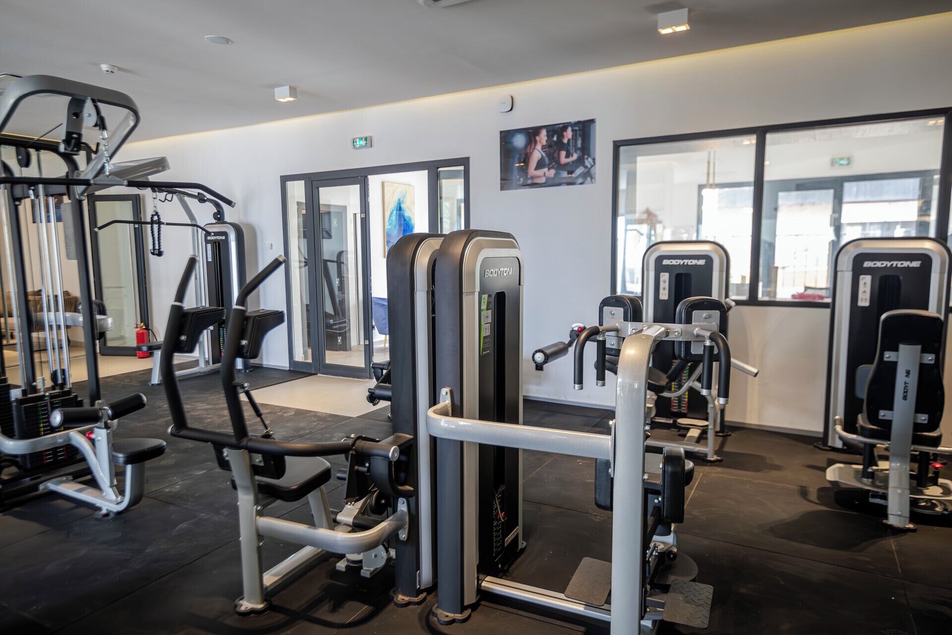A modern gym with various exercise machines, including weight stacks and cardio equipment.