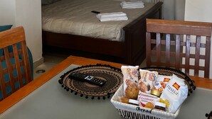 Ein gemütlicher Raum mit einem Steingewölbe, das zu einem Bett und einem Tisch mit einem Korb Brot führt. Ein Fernseher liegt daneben.