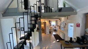 Un intérieur moderne comprenant un escalier, un coin repas et un espace de vie.
