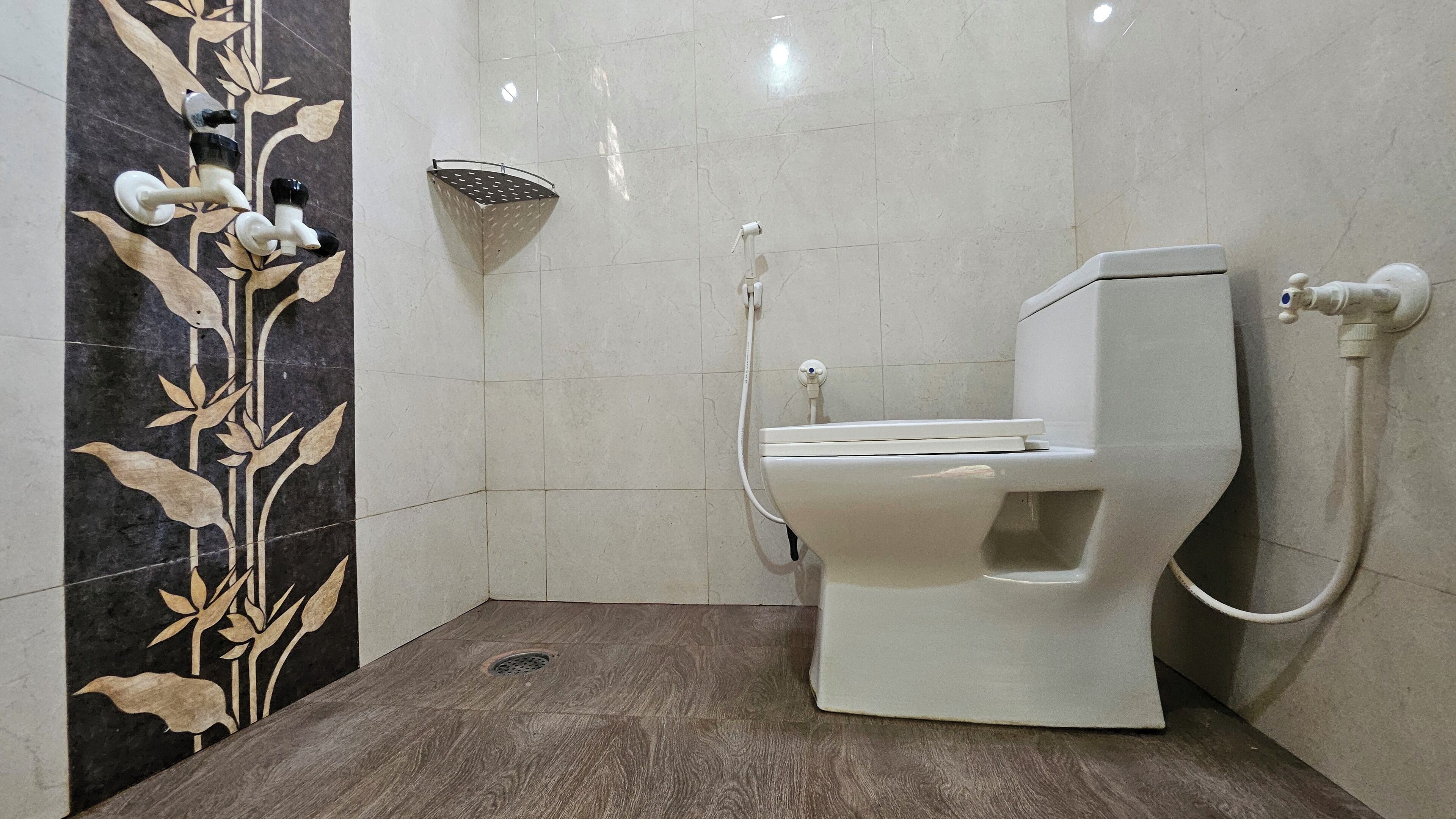 A modern bathroom with a toilet, a shower, and a decorative wall.