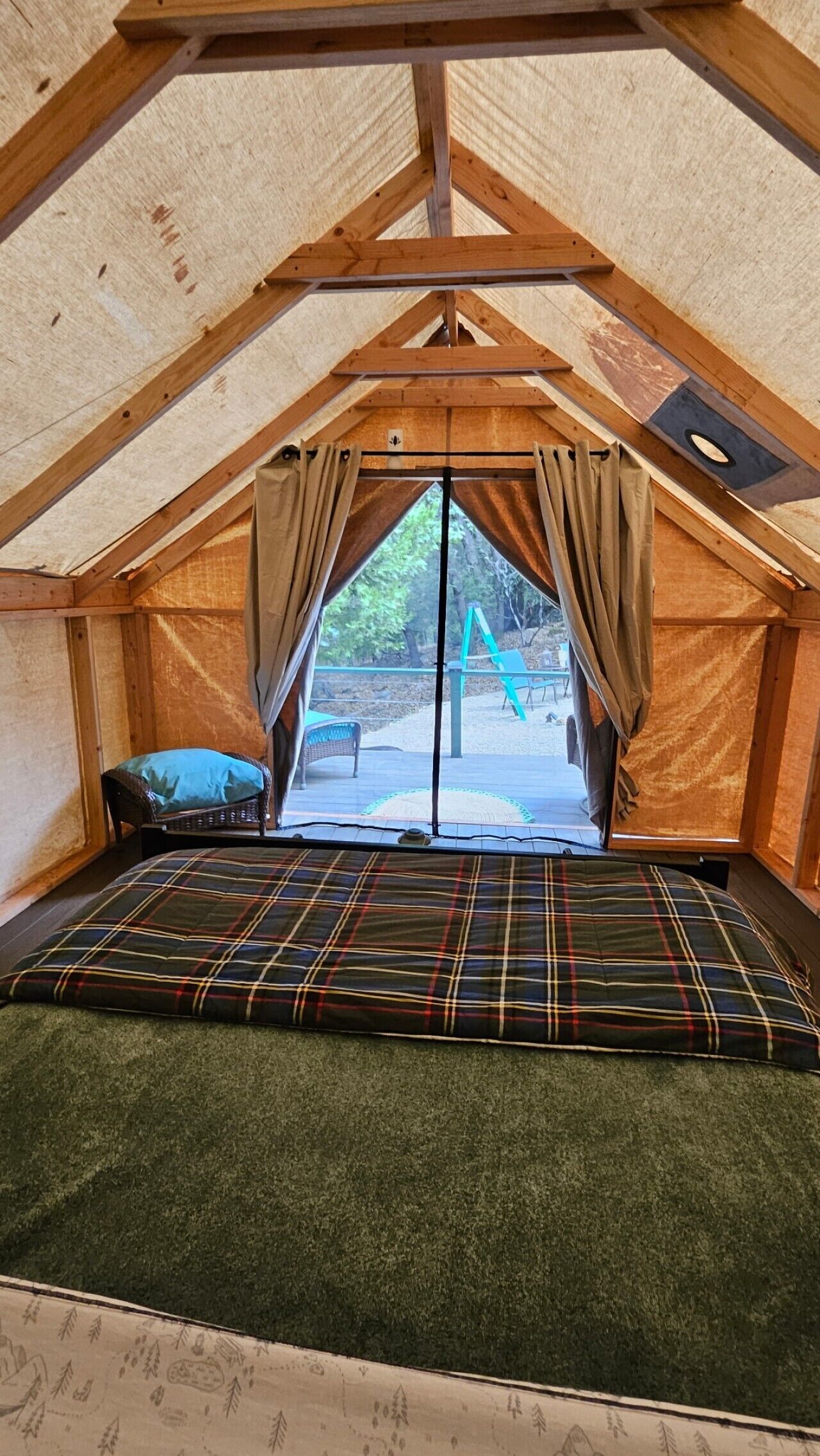 A tent with a sleeping area, a window, and a view of the outdoors.