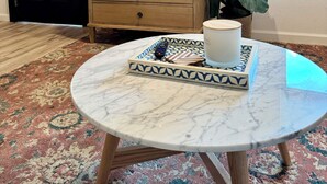 A room with a marble table, a wooden dresser, a television mounted on the wall, and a potted plant. - ꕥ The Texas Bluebonnet ꕥ 1.1 mi to Baylor, & 1.8 mi to Magnolia Silos! (Waco)