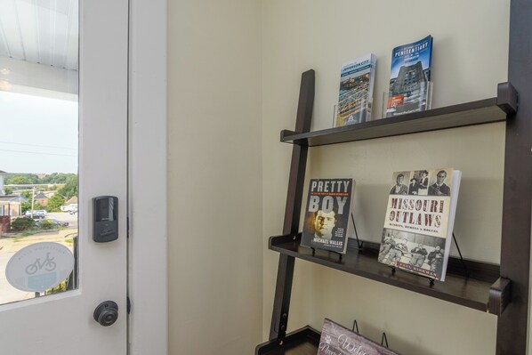 Una estantería con libros y una puerta con mirilla.