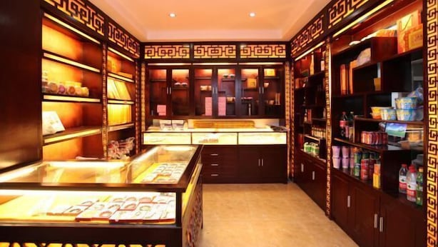 A well-lit, traditional-style room with wooden cabinetry and shelves filled with various items.