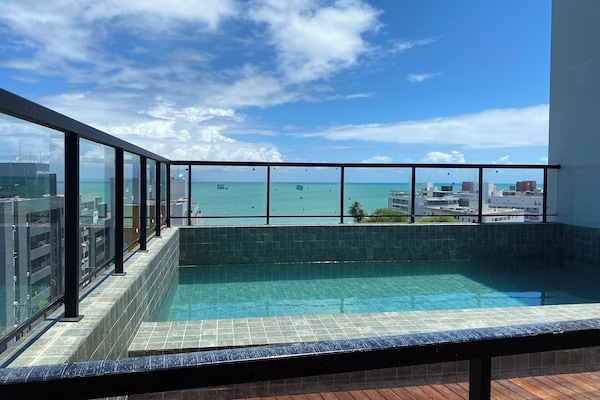 Una piscina al aire libre, sillones reclinables de piscina