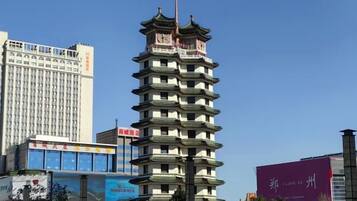 A multi-story building with a traditional architectural style, surrounded by modern high-rise buildings.