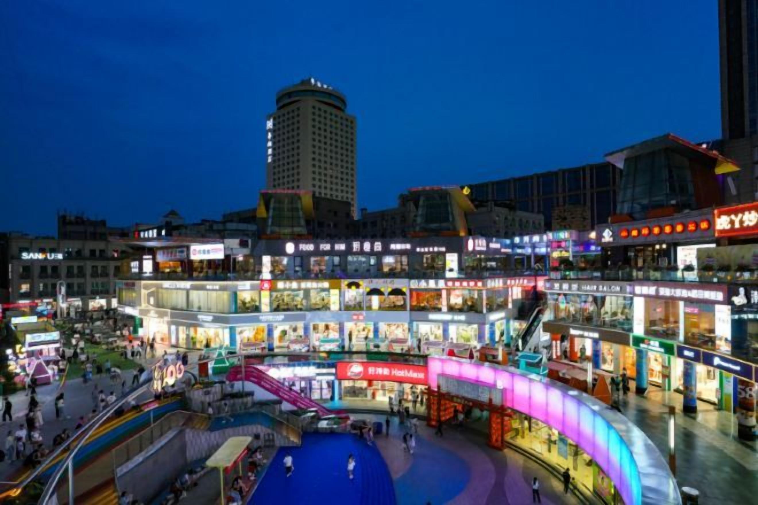 A multi-level shopping complex with various stores and a central open area.