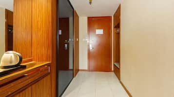 A hotel hallway with wooden doors and a reception desk.