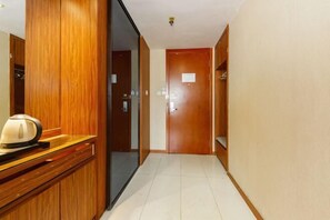 A hotel hallway with wooden doors and a reception desk. - shi bo hotel (Zhengzhou)