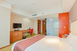 A hotel room with a bed, a desk with a chair, a television, and a wardrobe. - shi bo hotel (Zhengzhou)