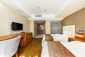 A hotel room with two beds, a desk, a television, and a bathroom door. - shi bo hotel (Zhengzhou)