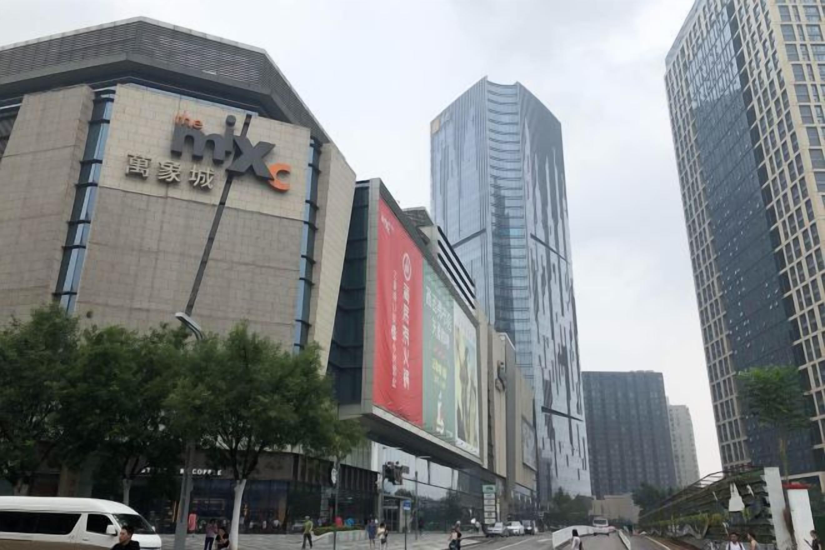A commercial building with a prominent 'mix' sign, surrounded by high-rise buildings and a busy street.
