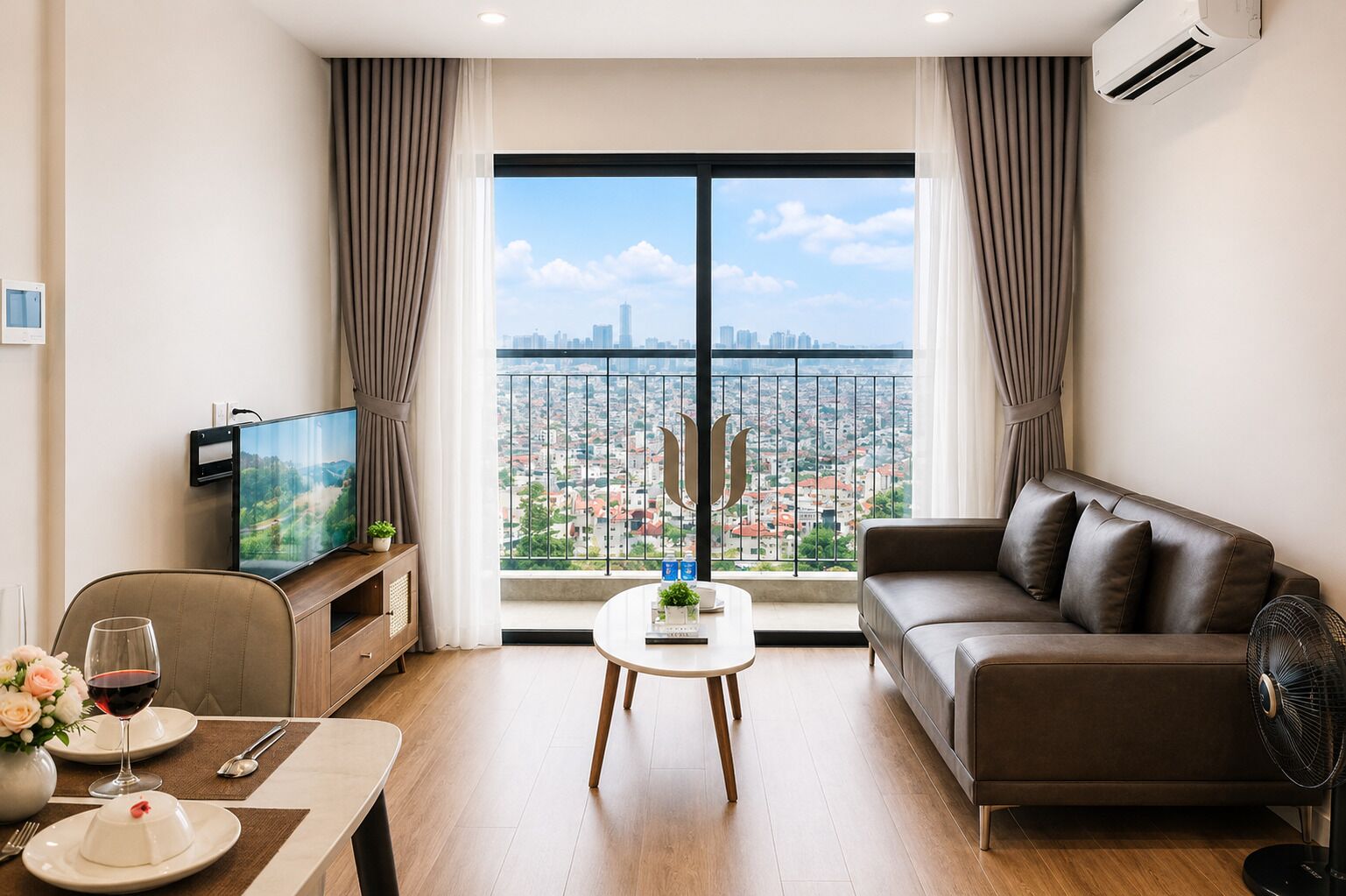 A modern living room with a large window, a sofa, a coffee table, a TV, and a dining area with a table set for two.