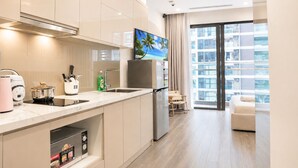 A modern kitchen with a built-in oven, a coffee maker, and a refrigerator. - 1 Bedroom Vinhomes Smart City (Hanoi)
