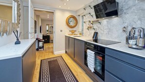 Una cucina moderna con rivestimento in marmo, forno integrato e un'ampia isola.