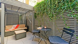 Un'area patio con un divano, due poltrone, un tavolino e una candela.