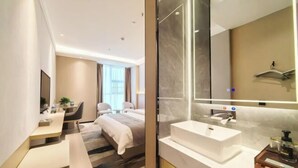 Una habitación de hotel moderna con cama, escritorio y baño.