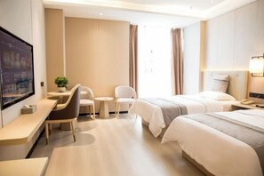 A hotel room with a bed, two chairs, a desk, a small table, and a TV. - Shengda Hotel (Guangshan)