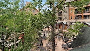 An outdoor patio area with tables and chairs, surrounded by trees and buildings. - Al8123-2 (Keystone)