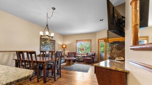 A spacious living area with a dining table, chairs, and a fireplace. - Al8123-2 (Keystone)