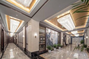 A hotel lobby with a marble floor, large chandeliers, and potted plants. - Grand Daqiao Hotel (Nanjing)