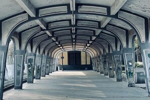 A corridor with a series of arches and columns, leading to a closed door at the end. - Grand Daqiao Hotel (Nanjing)