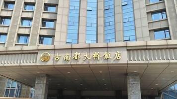 A hotel entrance with a modern facade, large windows, and a prominent sign.