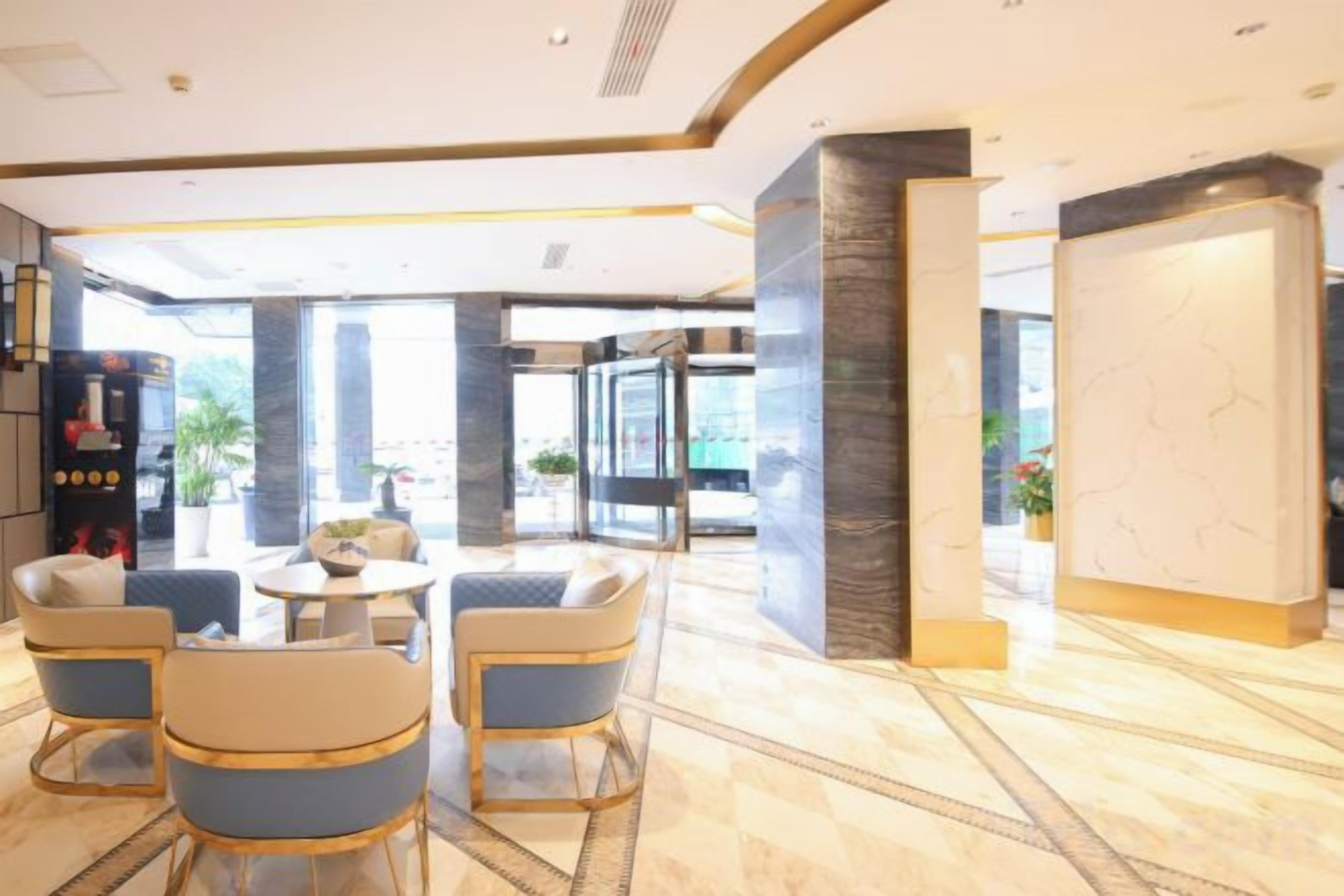 A lobby with a seating area, a reception desk, and a large marble wall.