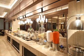 Eine Hotelküche mit Edelstahlgeräten, einer Marmorarbeitsplatte und Pendelleuchten.