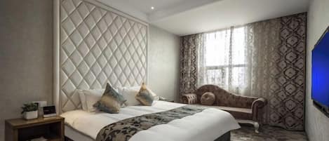 A hotel room with a large bed, a nightstand, a sofa, and a TV.