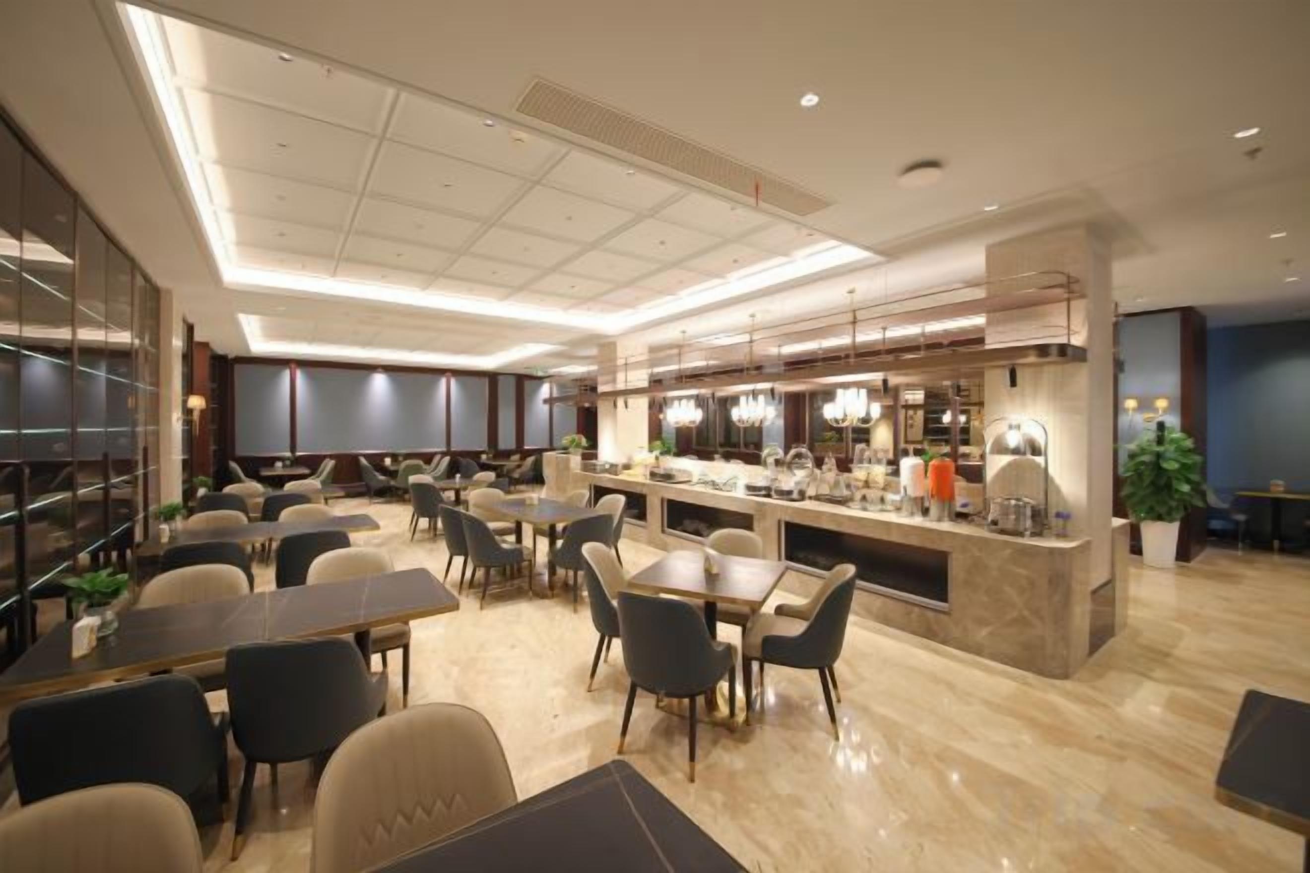 A modern restaurant with a central bar, multiple dining tables, and chairs.