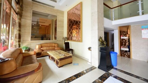 A spacious lobby with a modern design, featuring a large seating area with sofas and a coffee table, a decorative wall with a geometric pattern, and a glass railing overlooking the lower level. - Xiangshan Shipu Hongting Hotel (Xiangshan)