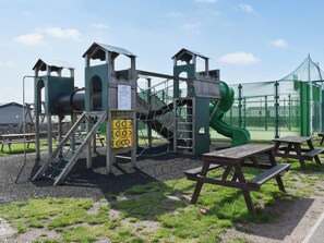 A playground with climbing structures, slides, and picnic tables.
