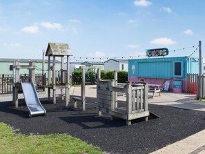 Ein Spielplatz mit Rutsche und Klettergerüsten.