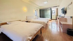 A hotel room with two beds, a desk, a television, and a sliding door leading to a balcony. - Cheng Yuan Express Hotel (Jurong)