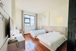 A hotel room with two beds, a desk with a telephone, a television, and a window with curtains. - Jurong Chengyuan Express Hotel (Maoshan Scenic Area Branch) (Jurong)