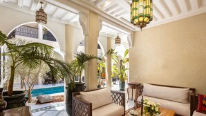 Un área interior amplia con piscina, asientos y plantas decorativas.