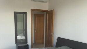 Une chambre à coucher avec un lit, une commode, un miroir et une porte.