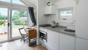 Una cocina moderna con un amplio ventanal, una tetera y un lavabo.