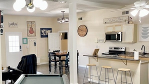 A pool table, dining area, kitchen, and bar area in a home. - Fun 2 BdRm Apt in the Bourbon Capital with Pool Table, PAC-Man & More! (Bardstown)
